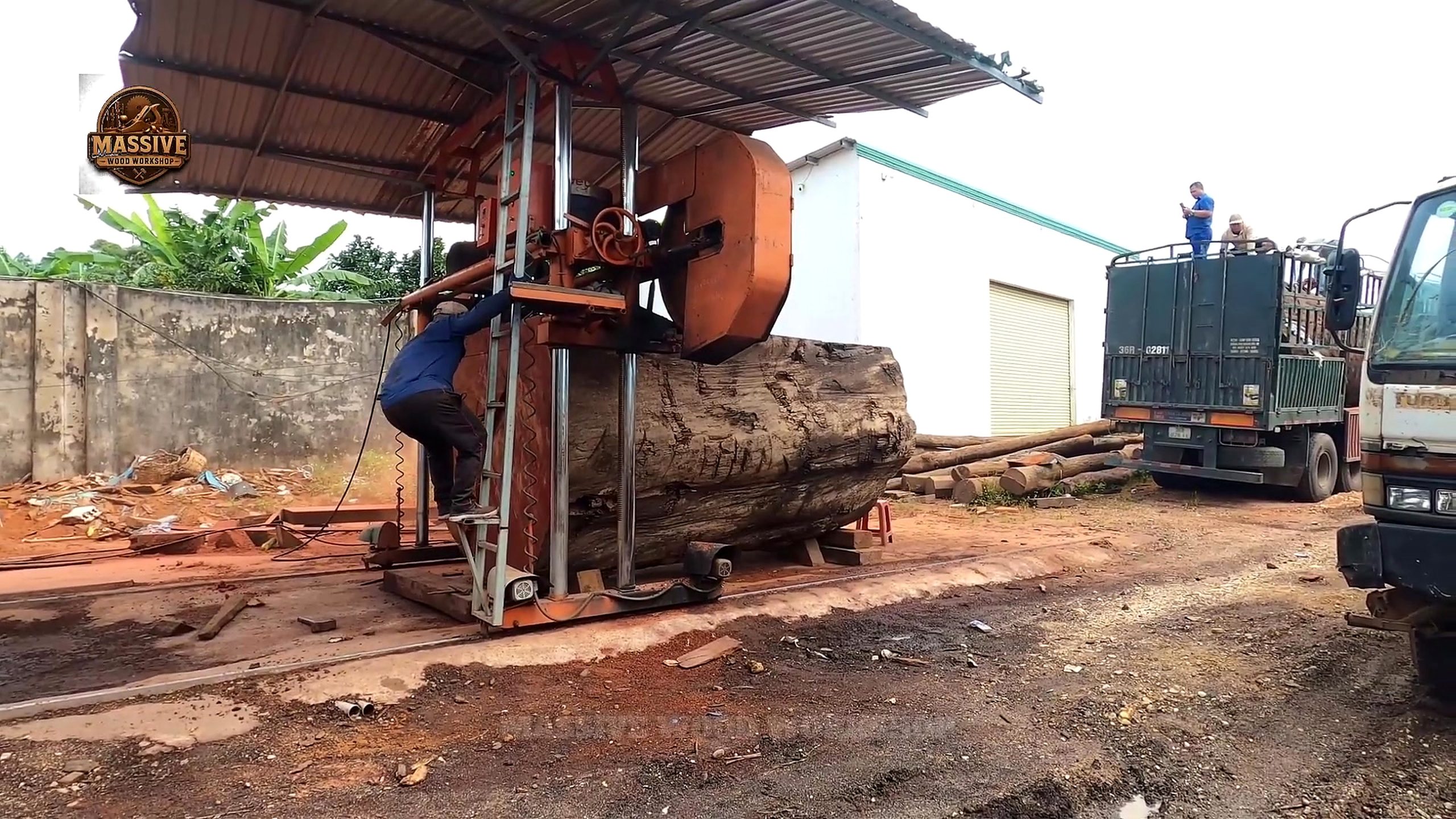 giant log round tabletop cutting process with orange band saw positioning and log support