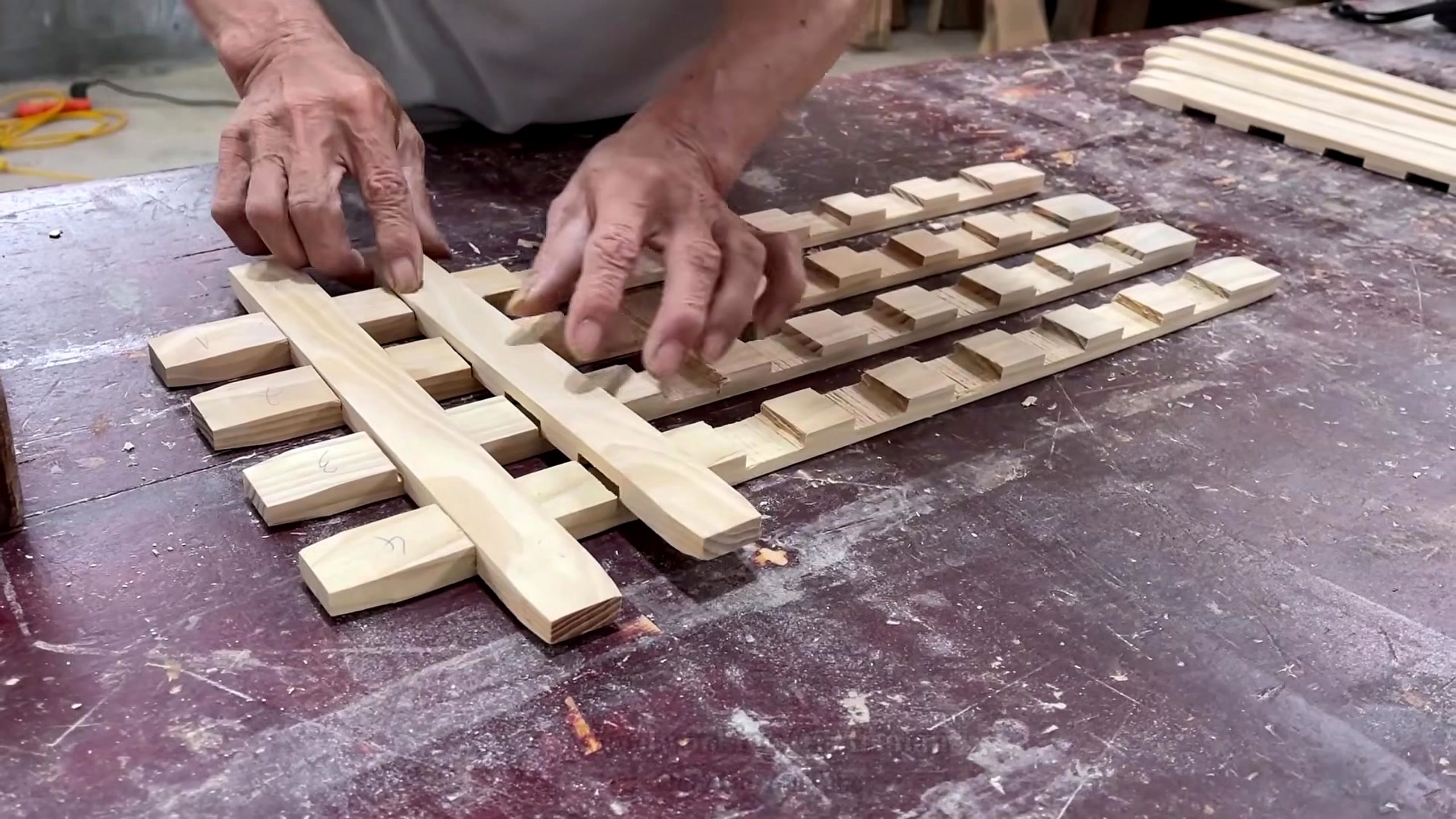 circular wood pedestal lattice furniture workflow - small wood blocks being arranged into a lattice pattern on the bench