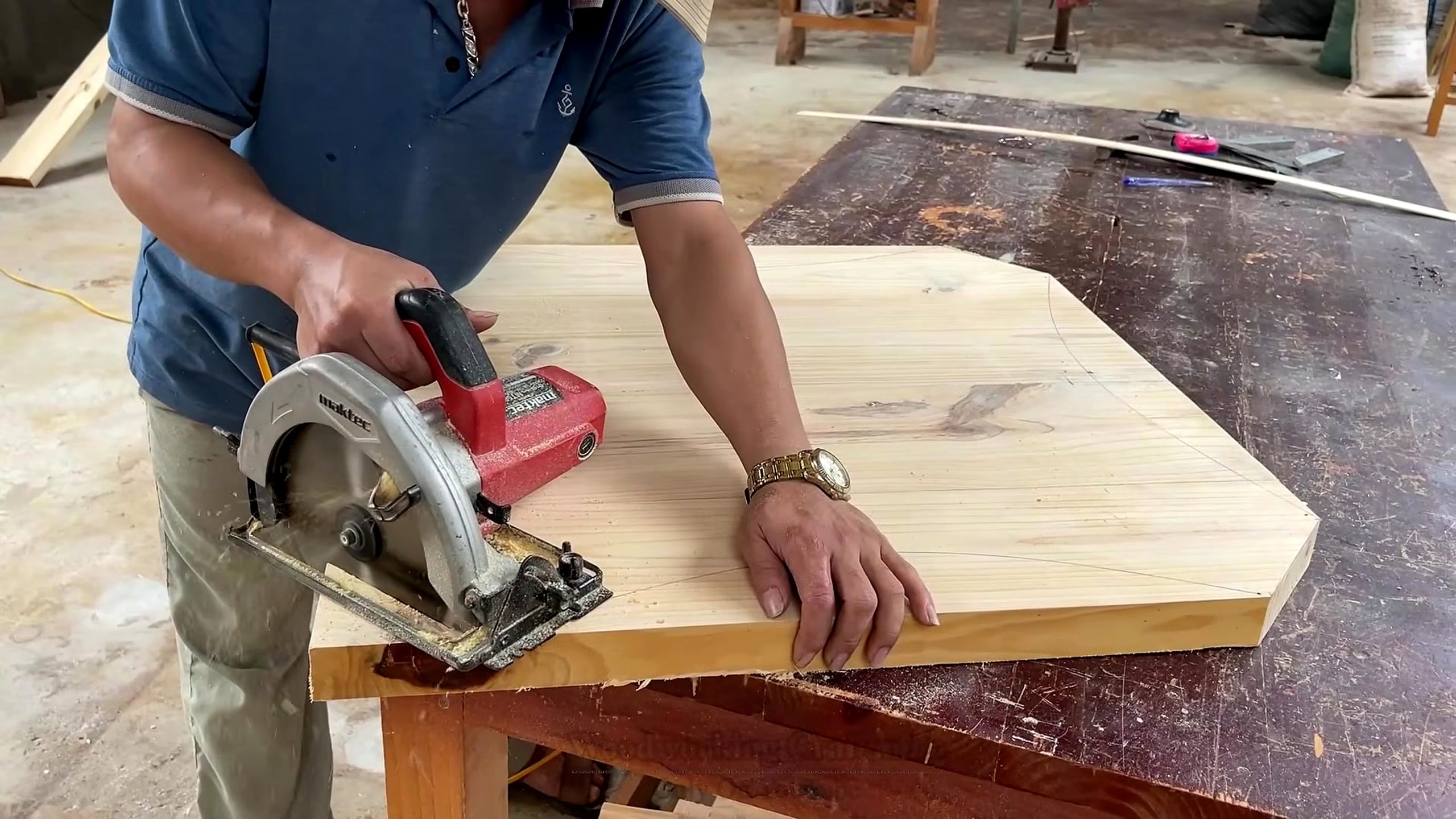 circular wood pedestal lattice furniture workflow - a large pale wood panel being trimmed with a handheld circular saw on the bench