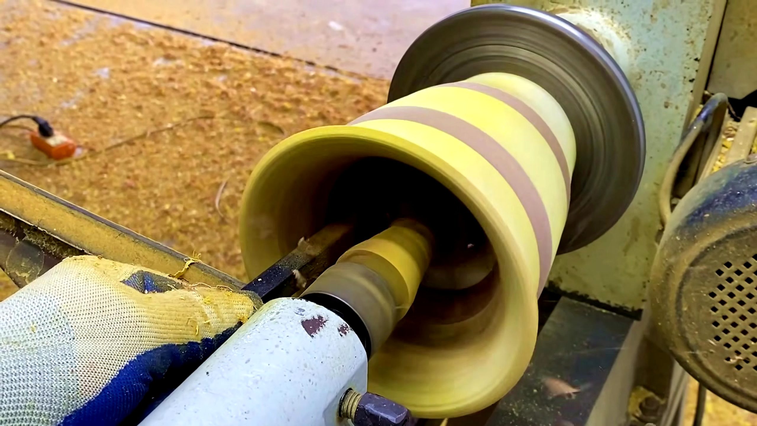 laminated wood bowl turning process - the hollow vessel profile being reviewed while still mounted on the lathe