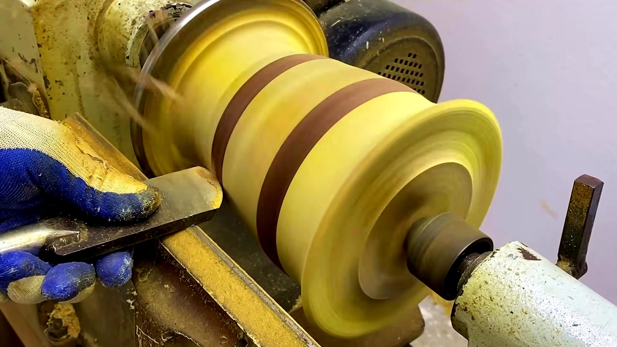 laminated wood bowl turning process - a hand-held turning tool refining the bowl wall and rim