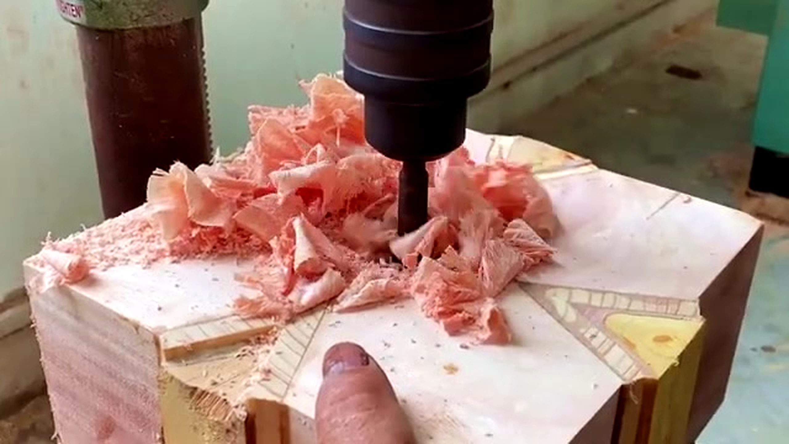 patterned wood lathe bowl process - a drill or boring bit removing waste from the marked blank