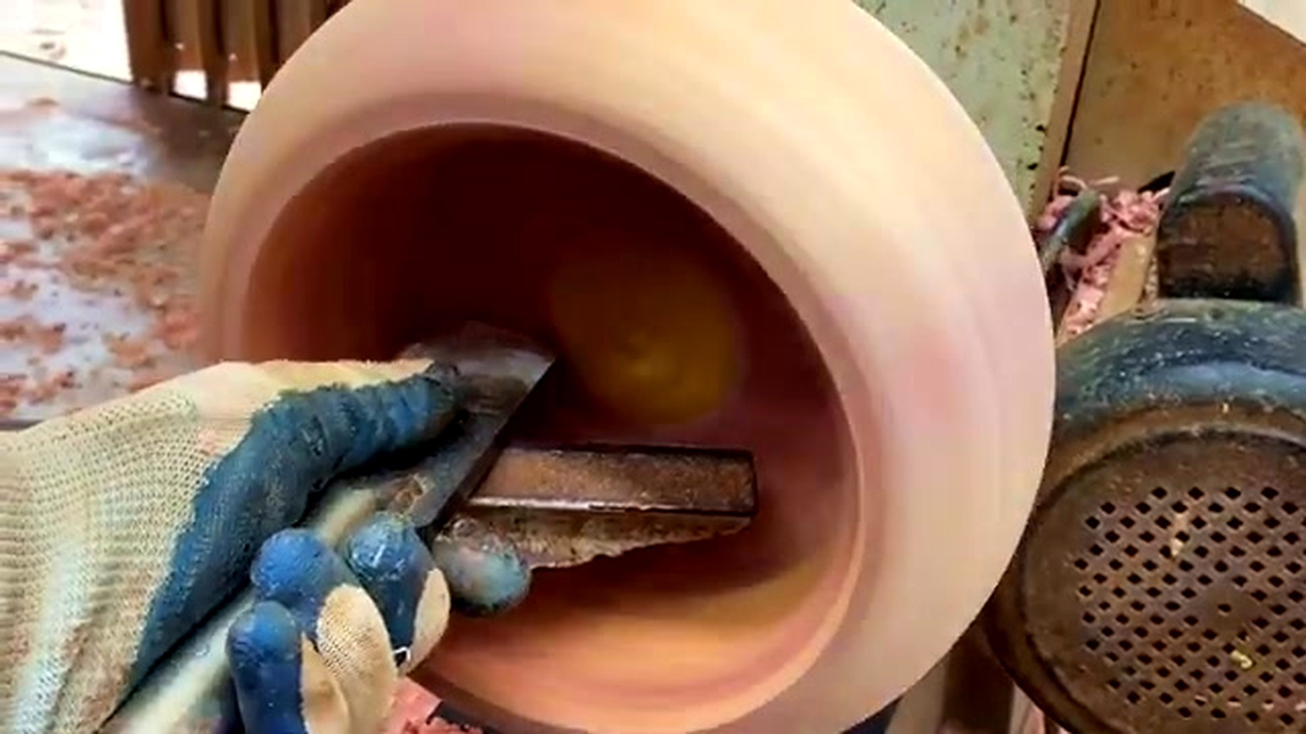 patterned wood lathe bowl process - a hand-held tool hollowing the bowl interior while chips collect inside