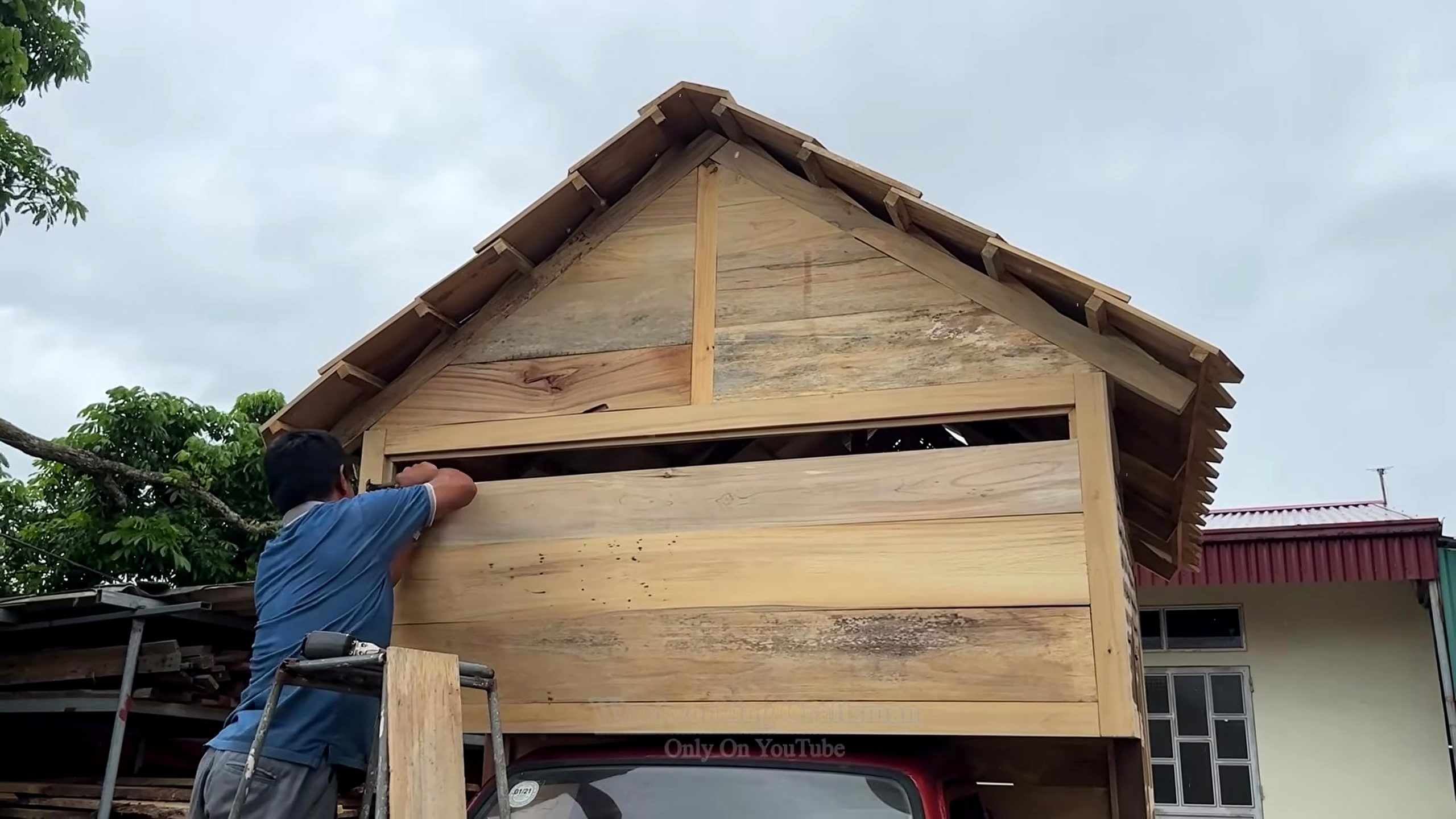 see guy did cherry wood logs wall cladding stage on the wooden house frame