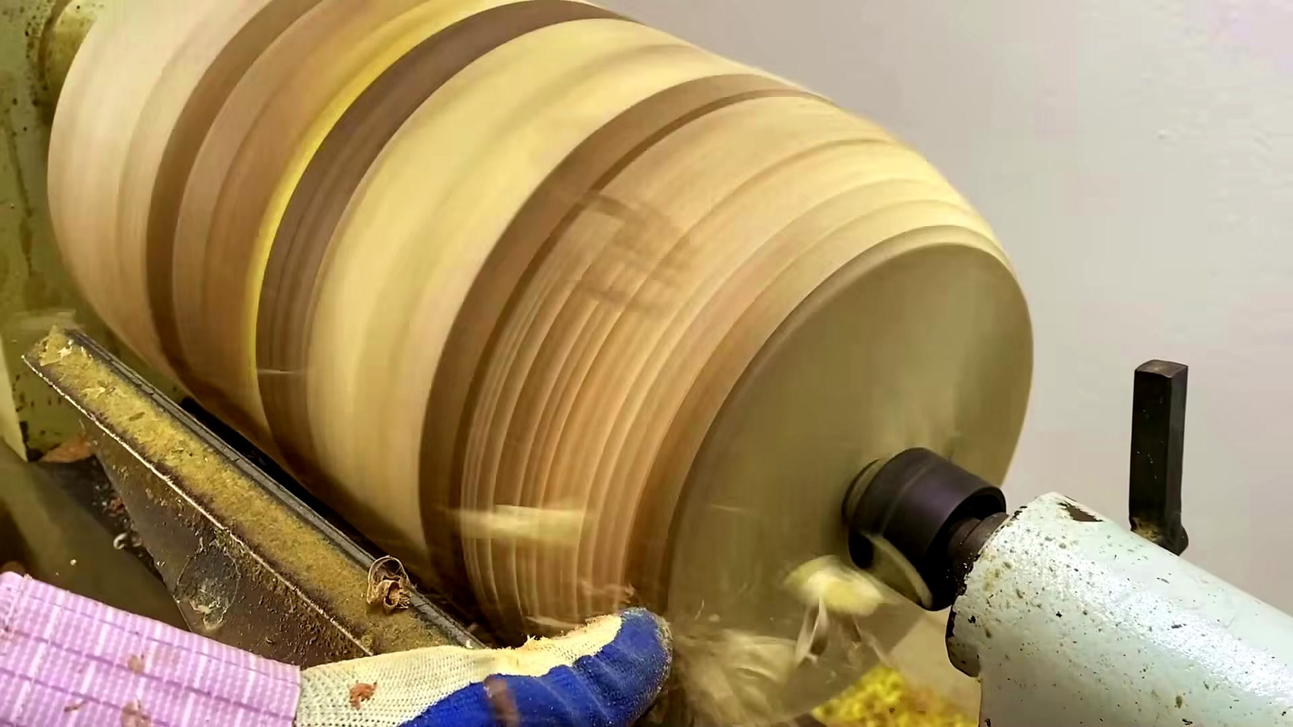 segmented wood lathe bowl process - the striped blank spinning on the wood lathe during outside shaping