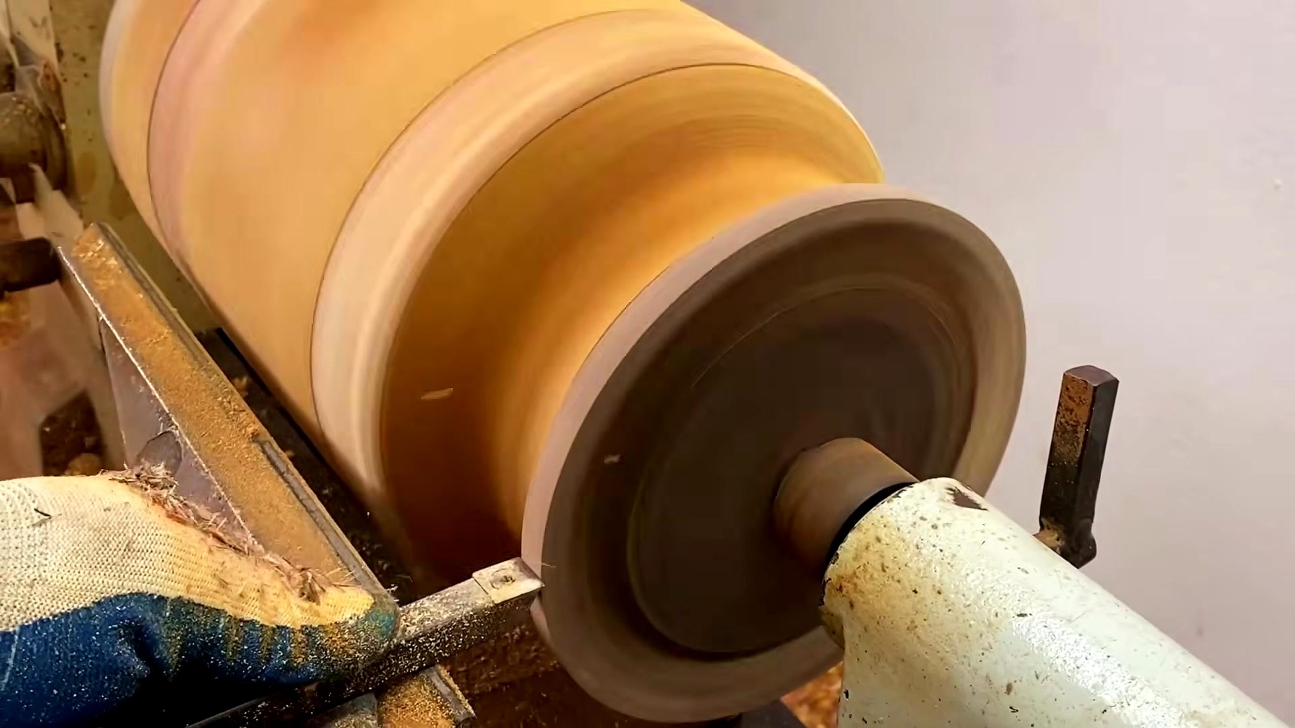 solid wood lathe bowl turning process - the solid wood blank mounted on a wood lathe before the outside profile is refined