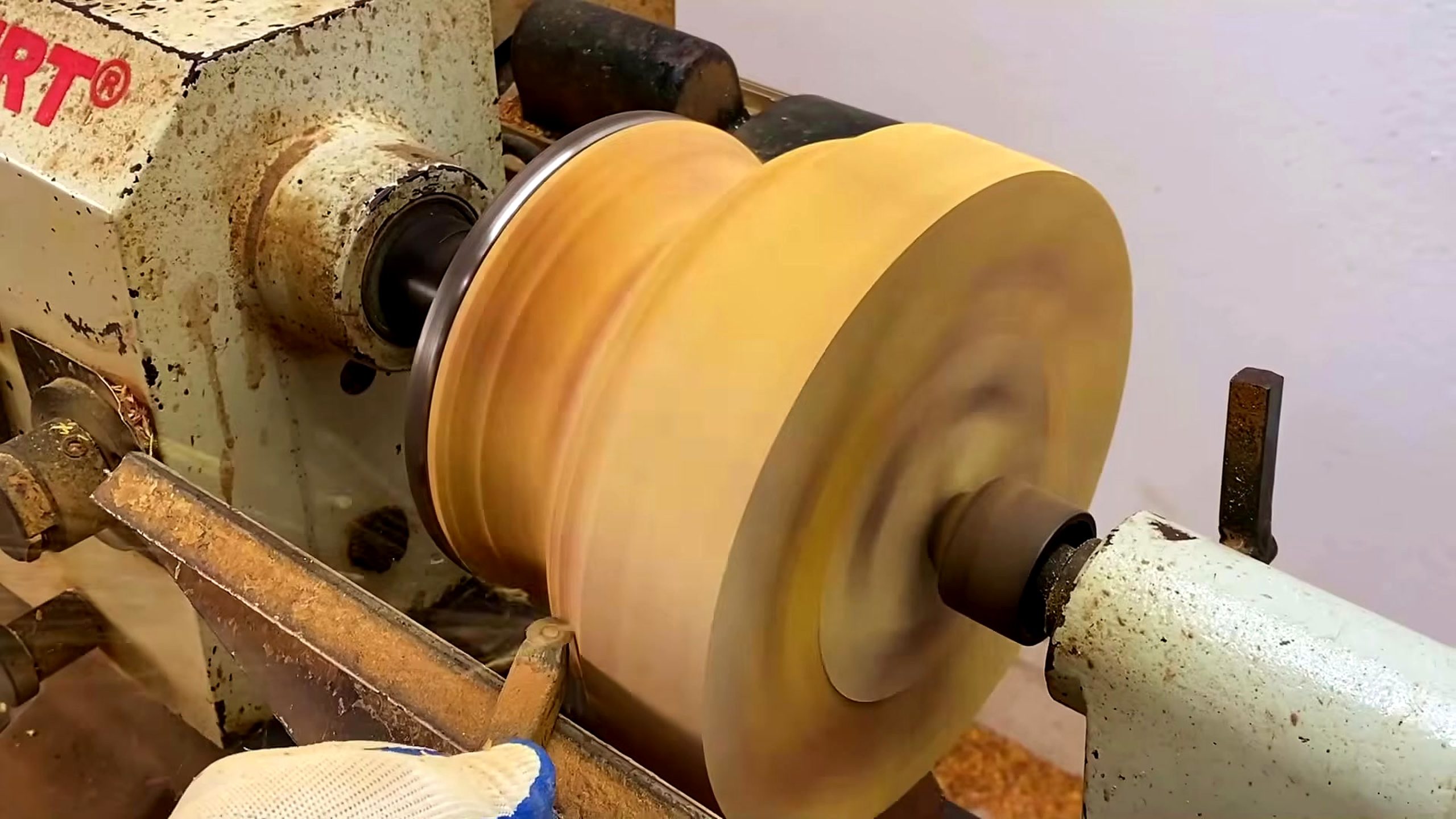 solid wood lathe bowl turning process - a hand-held turning tool roughing the outside of the spinning blank