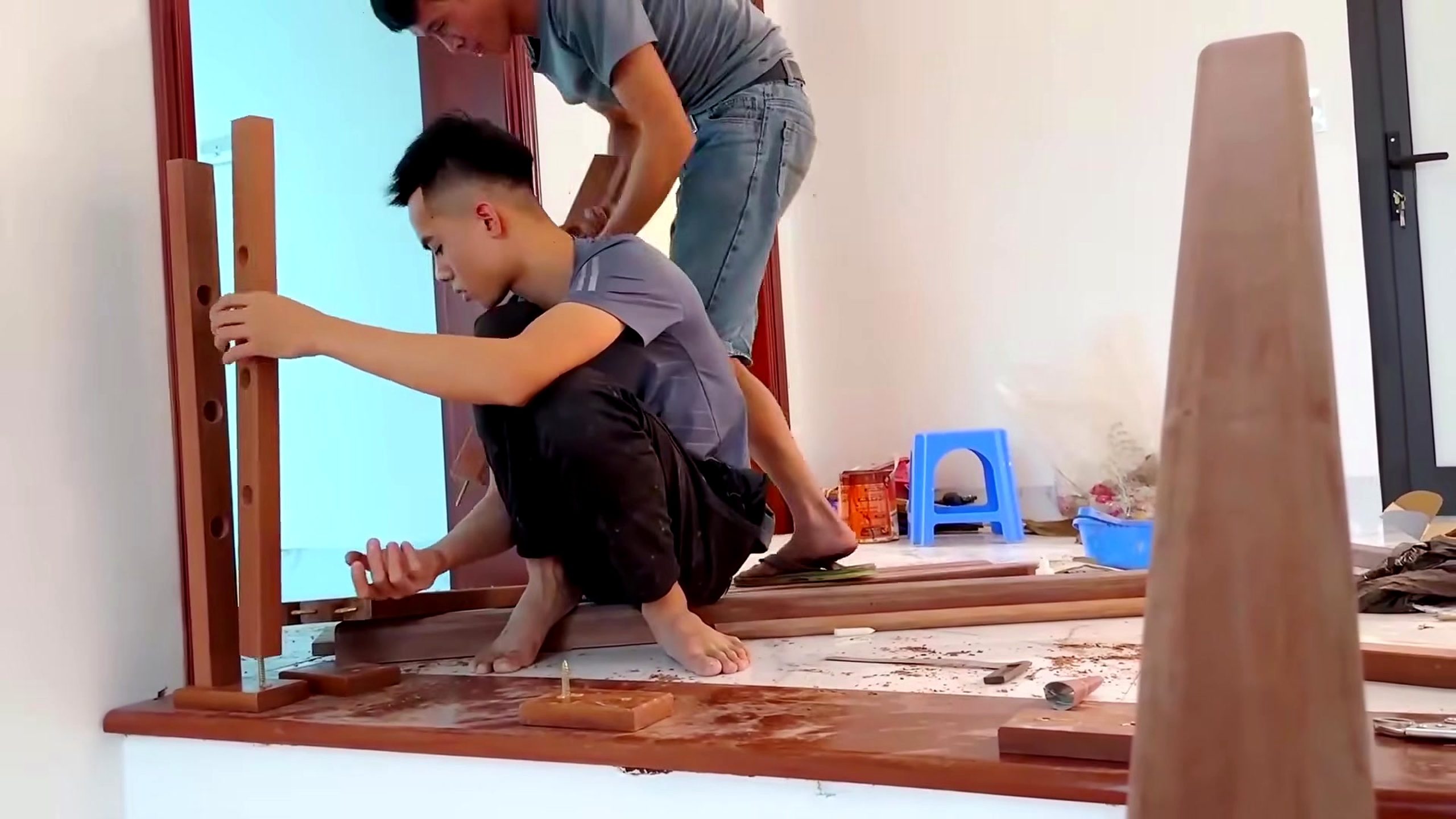 woodworker builds installs wooden stair railing - a detail-check moment that helps readers inspect the process
