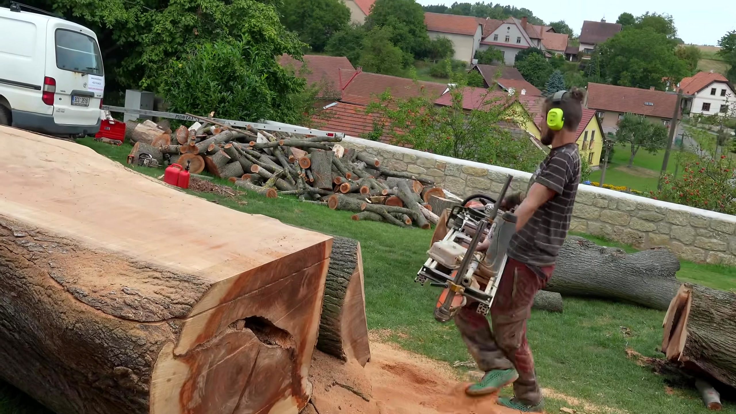 chainsaw milling giant log into solid boards - a broad flat face exposed on the giant log while natural edges and end defects remain visible