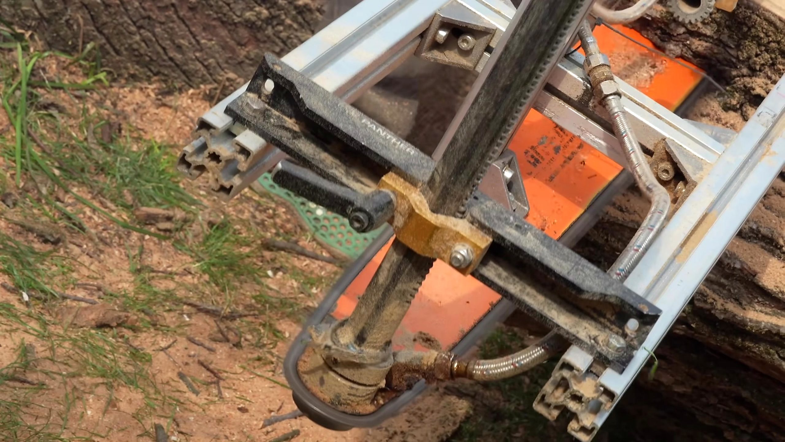 chainsaw milling giant log into solid boards - the portable chainsaw-mill frame, guide rails, powerhead, and cutting bar at the workpiece