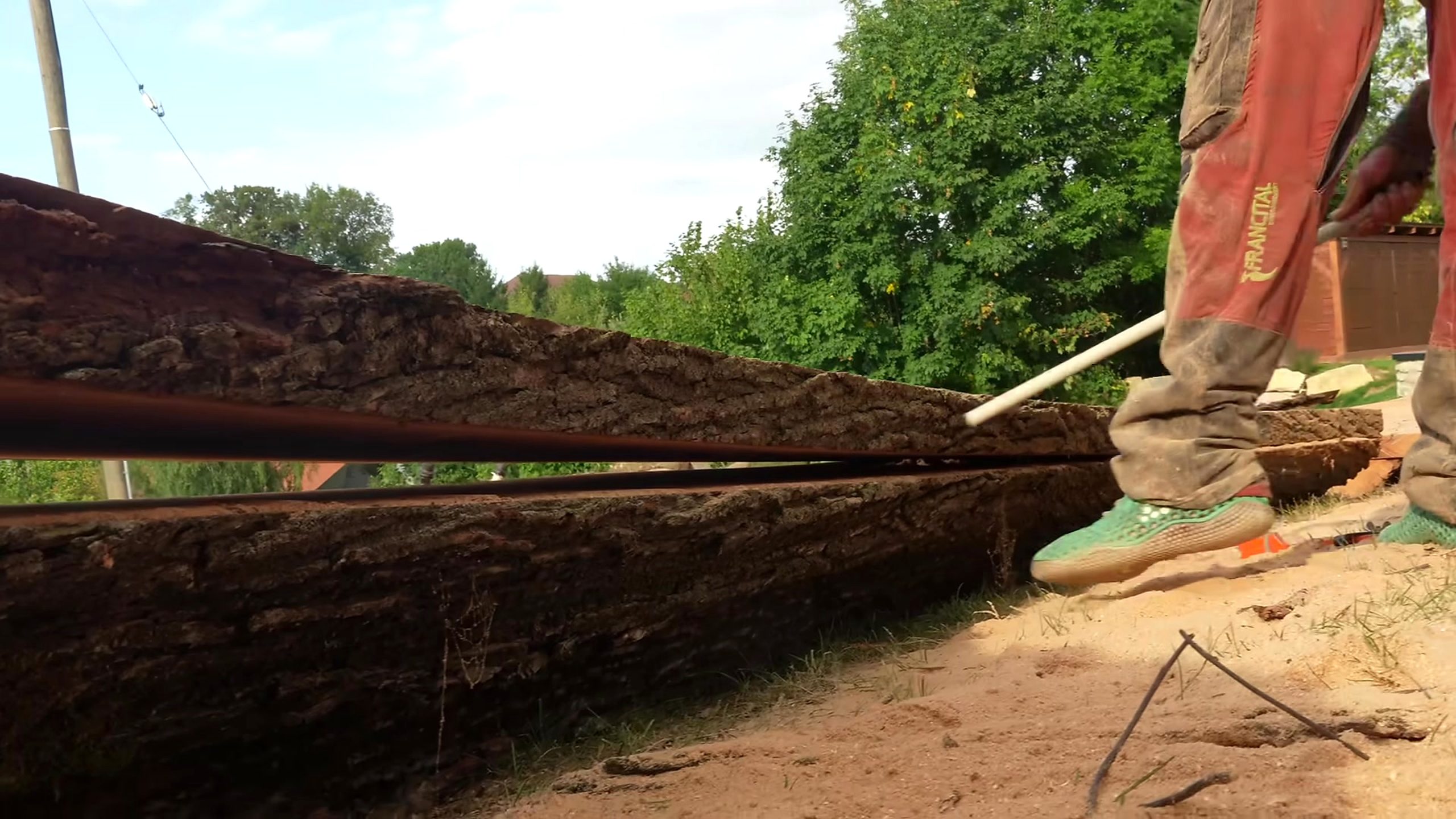 chainsaw milling giant log into solid boards - long live-edge material separated after milling and checked before later drying or board preparation