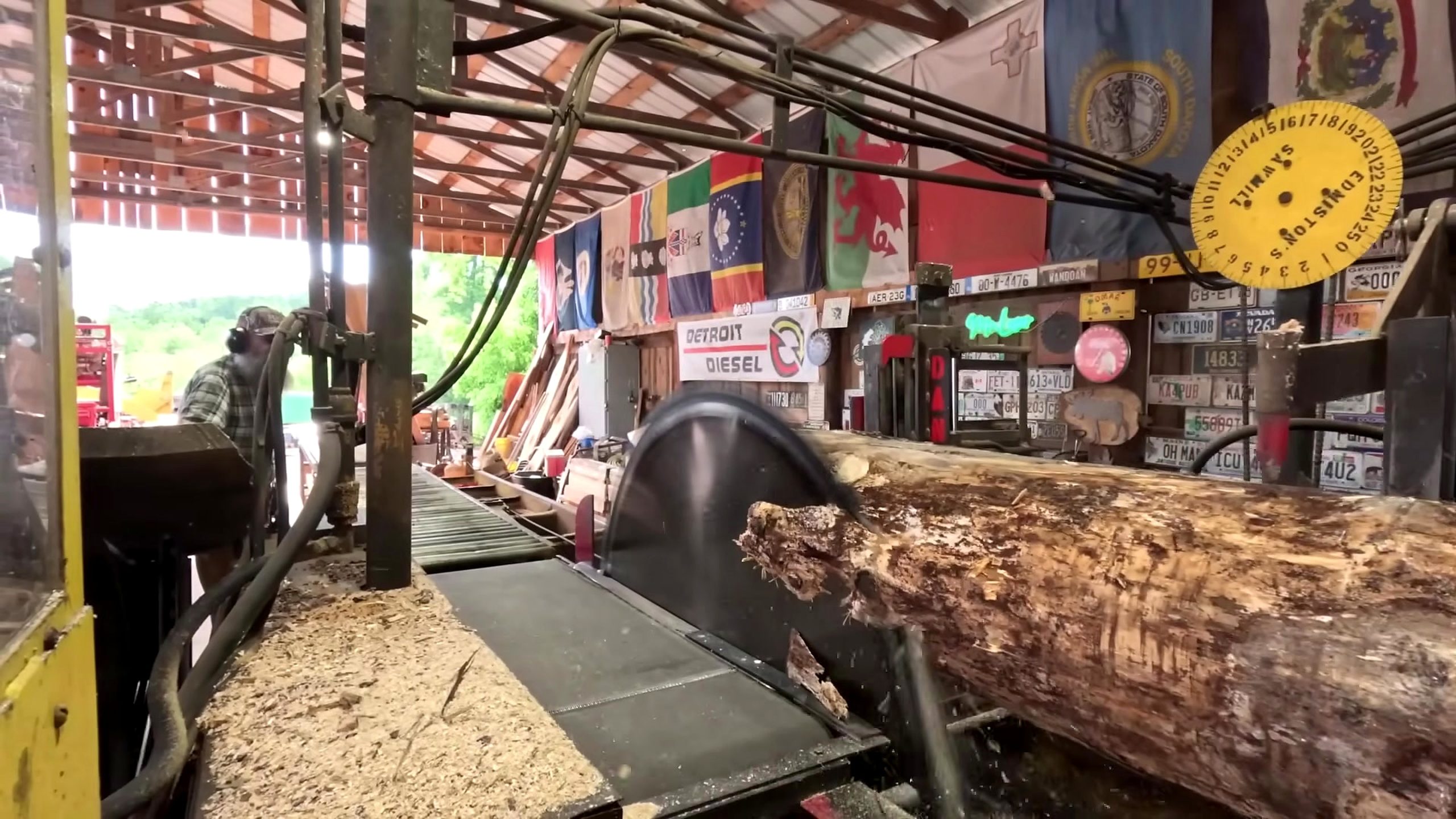 bark-covered log aligned on a sawmill carriage for sawing 2x8 boards for a shed floor
