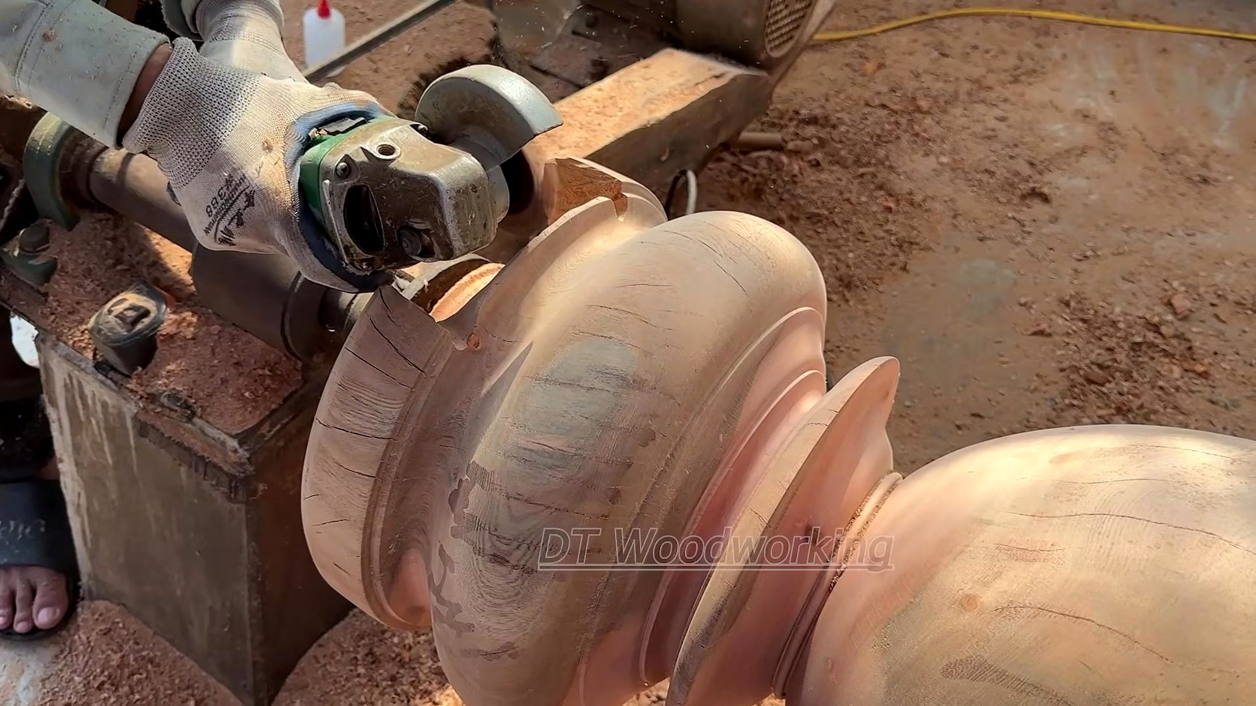 giant burnt log woodturning process - a handheld abrasive tool refining a flared ring on the turned form