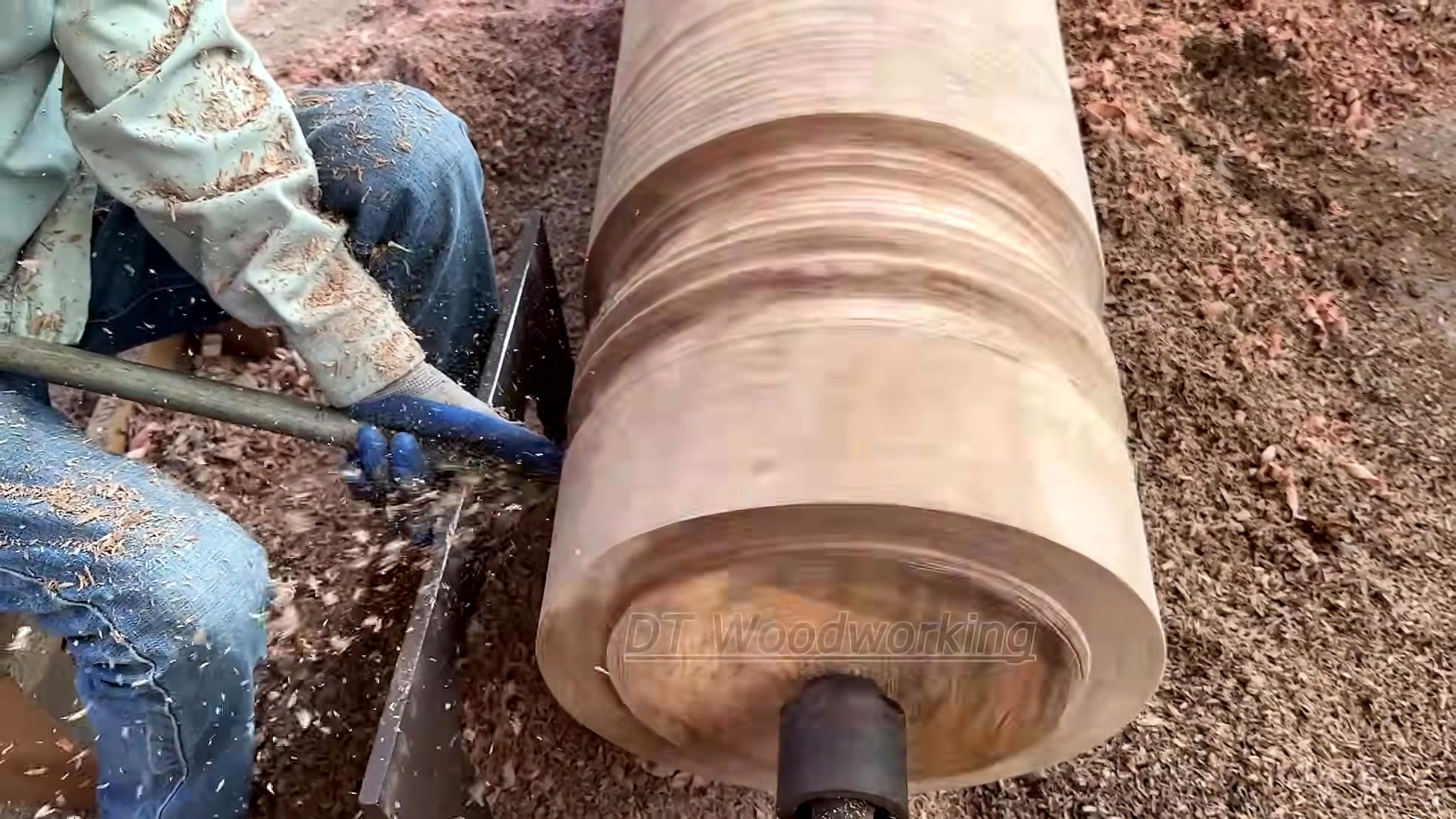 giant burnt log woodturning process - a long supported turning tool shaping the large outside profile