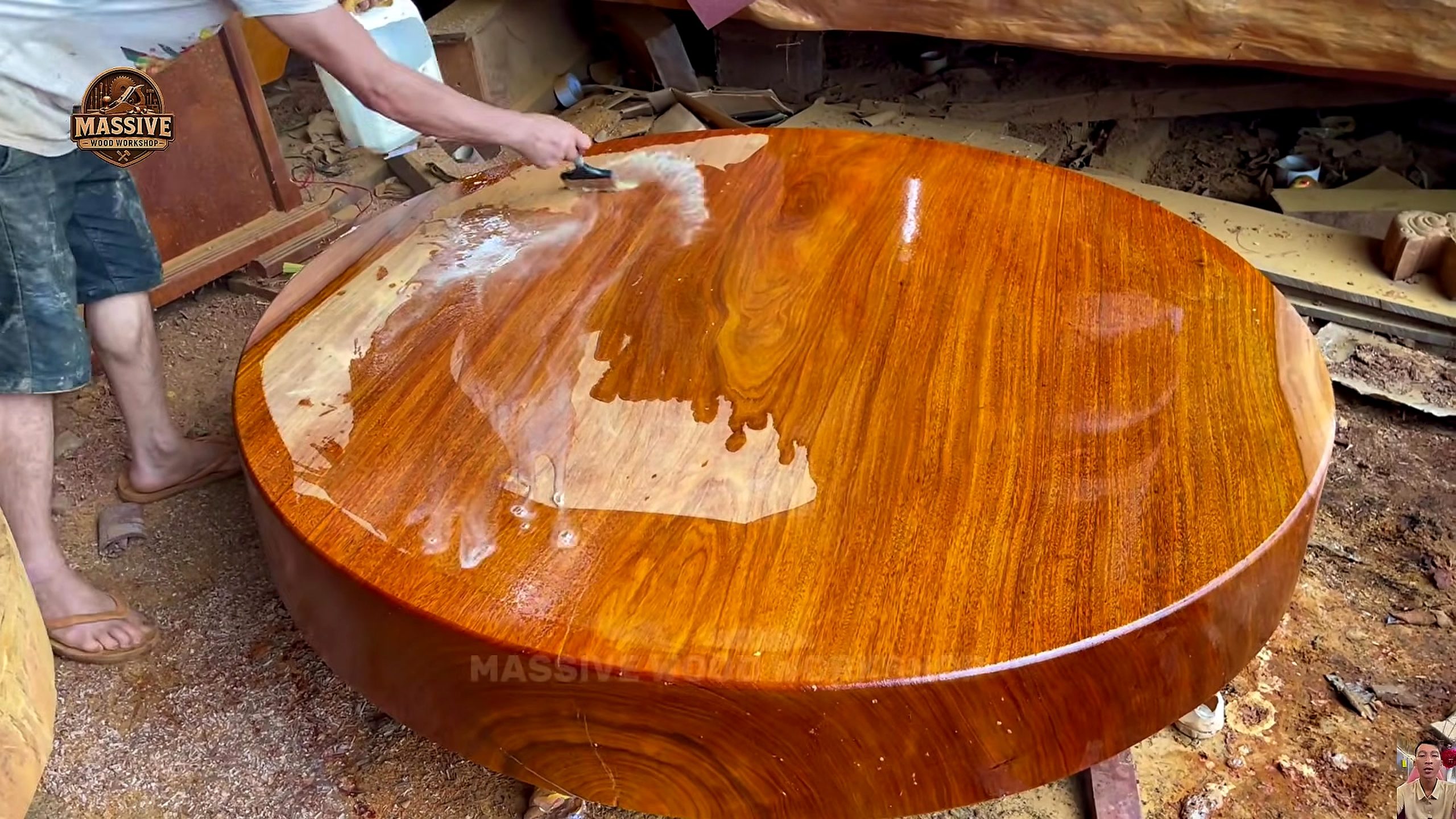 giant timber bandsaw round table process - liquid finish being spread across the round tabletop