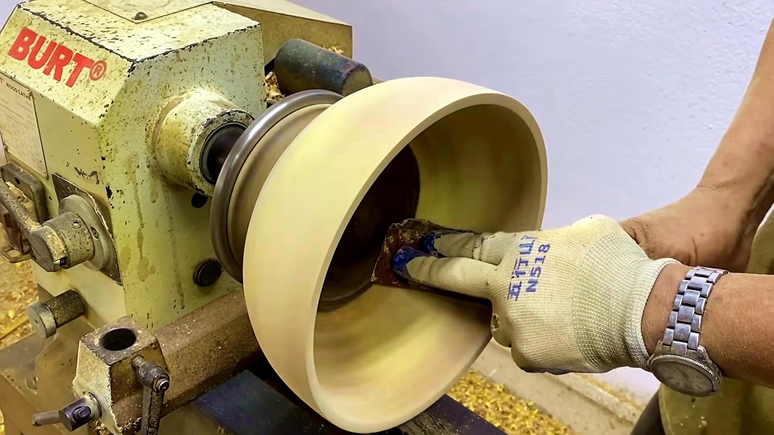 homemade wood lathe bowl process - the maker checking the rim and inside wall after turning