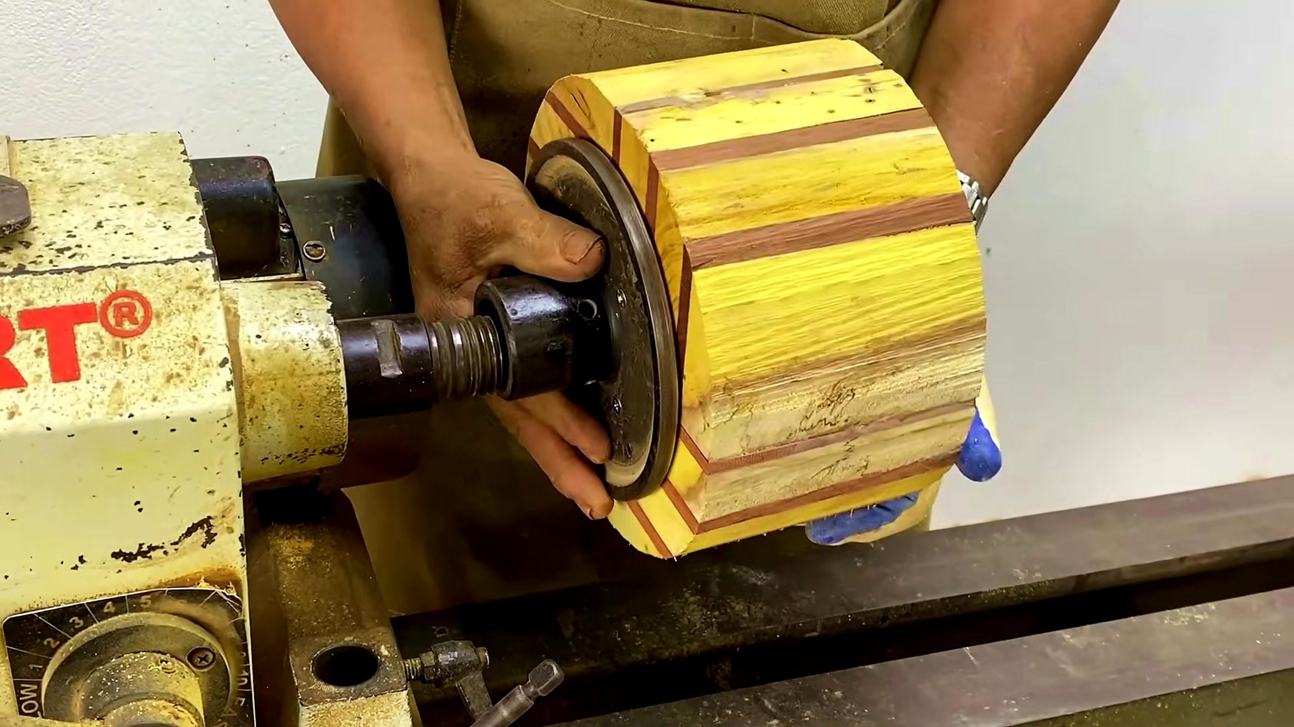 laminated wood disk turning process - a colored disk blank mounted on the wood lathe before shaping