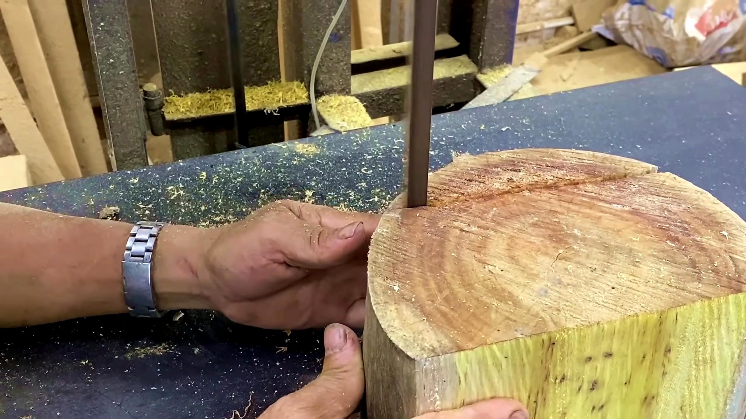 laminated wood disk turning process - a round wooden blank being guided near a vertical bandsaw blade