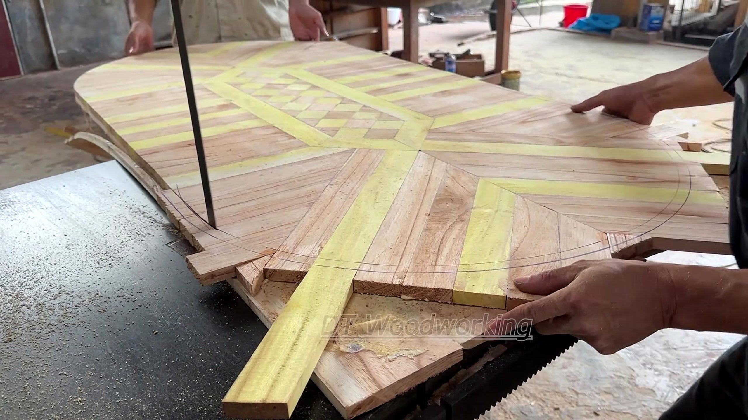geometric marquetry furniture making process - contrasting pieces arranged and hand-trimmed into a radial geometric panel