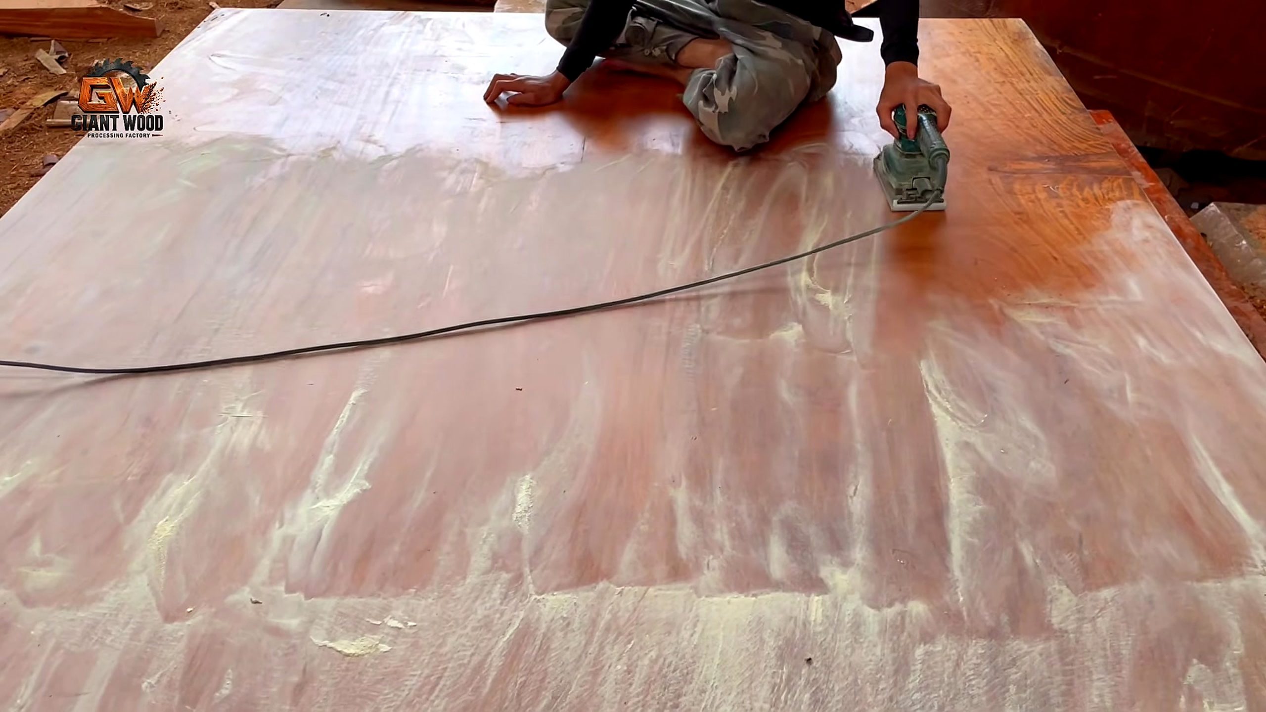 giant log vertical bandsaw sculptural table process - a handheld power tool following the curved tabletop layout on the pale surface