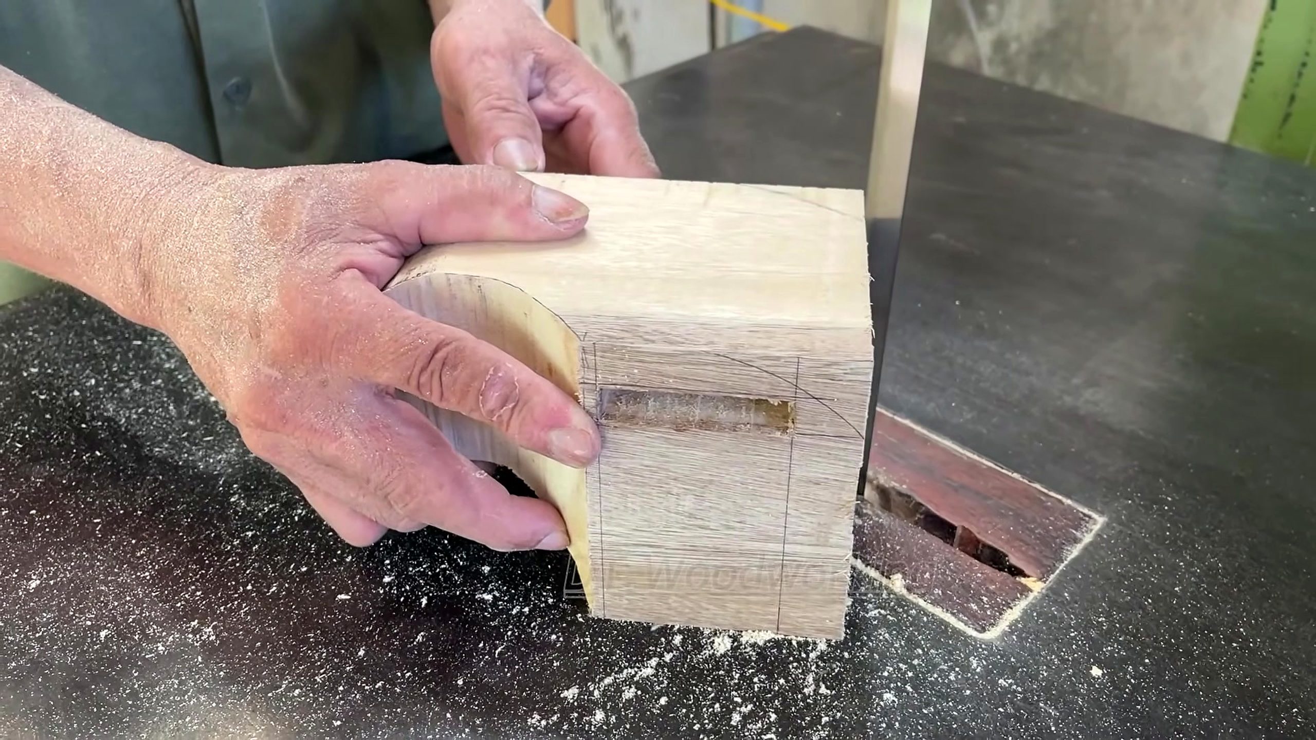 redwood panel mortise and bandsaw furniture workflow - holding a marked pale block at the shaping or bandsaw station