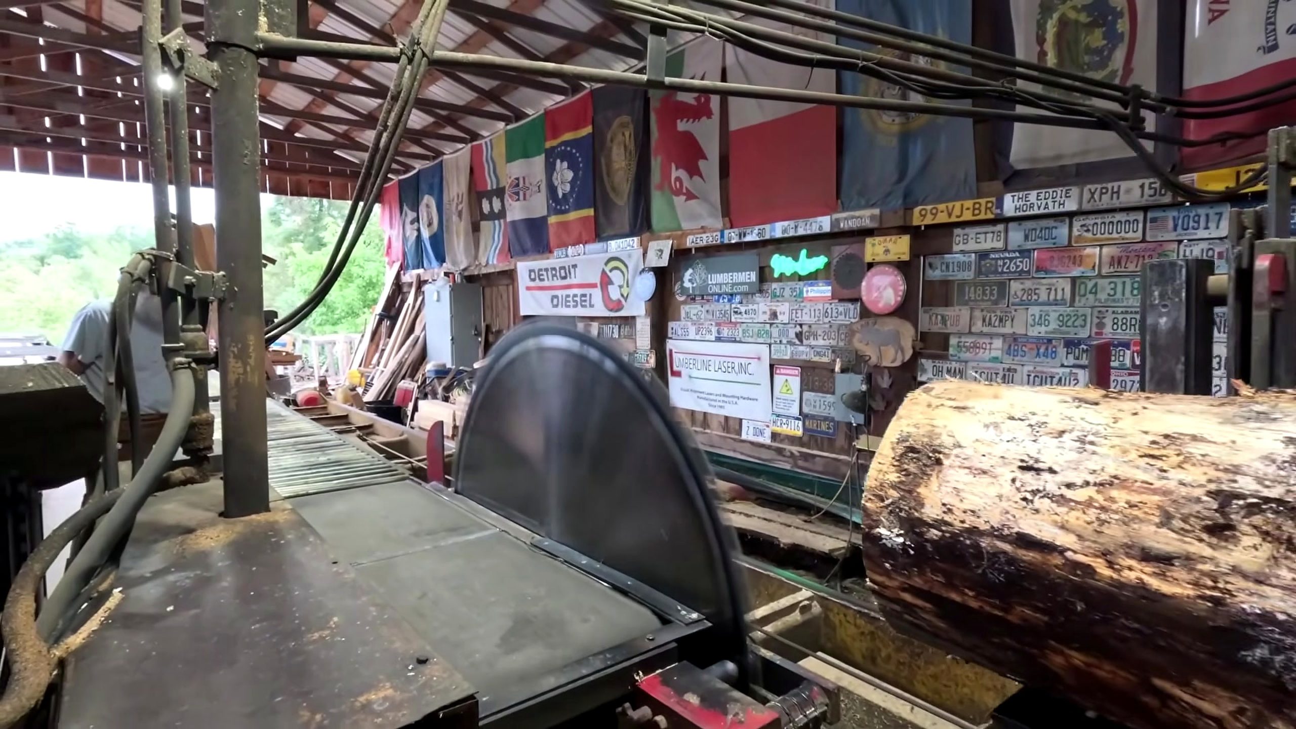sawmill chop saw blade and log crosscut workflow - a round log restrained on the carriage beside the circular blade