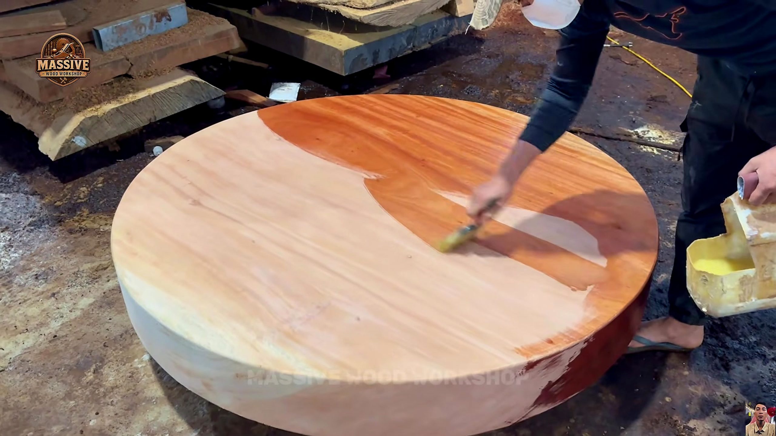 weathered giant timber round table process - liquid finish being spread across the round top with wet and dry zones visible