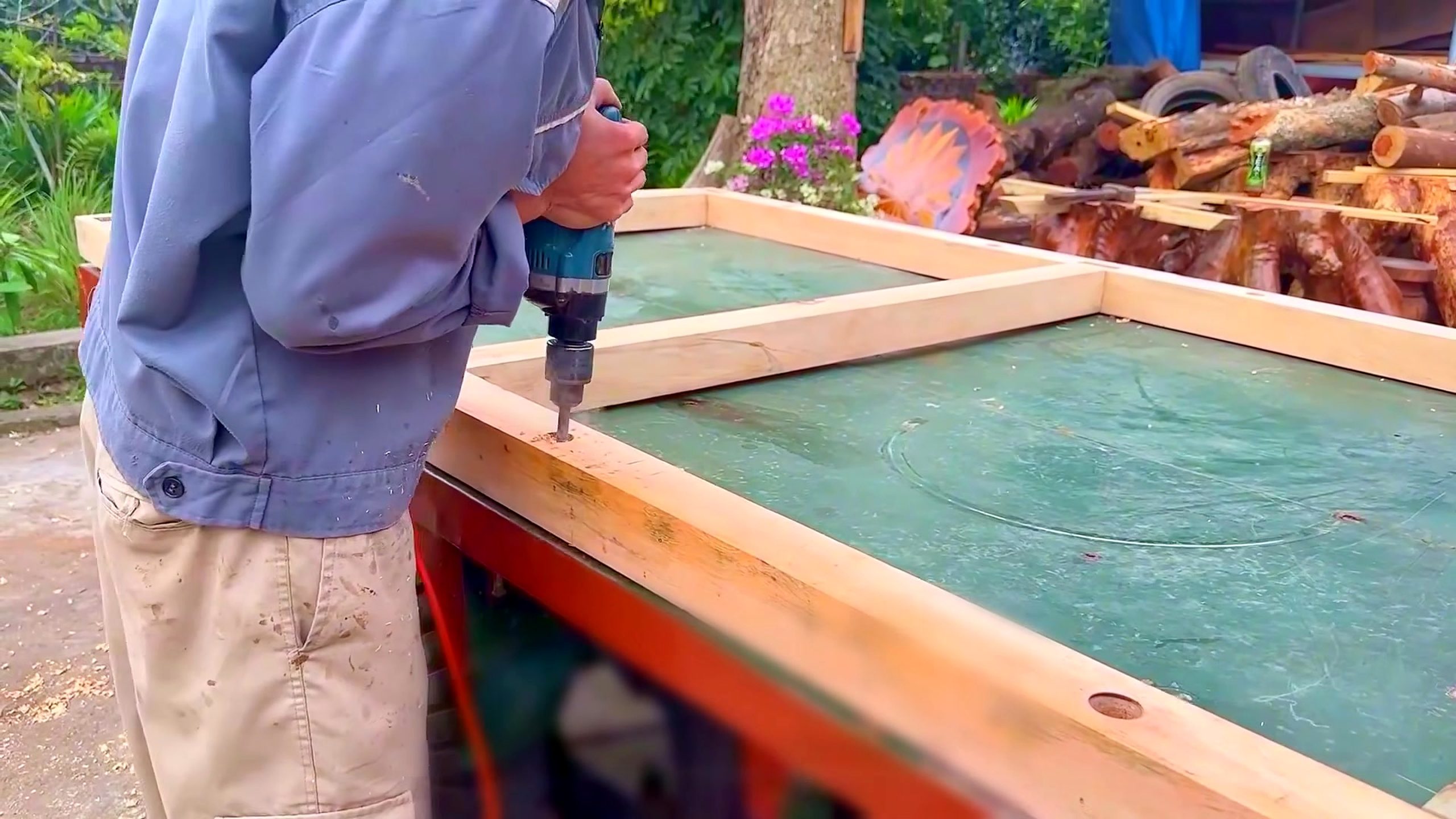 wood and bamboo pavilion build with miter saw - a drill-driver fastening the corner of a rectangular timber frame