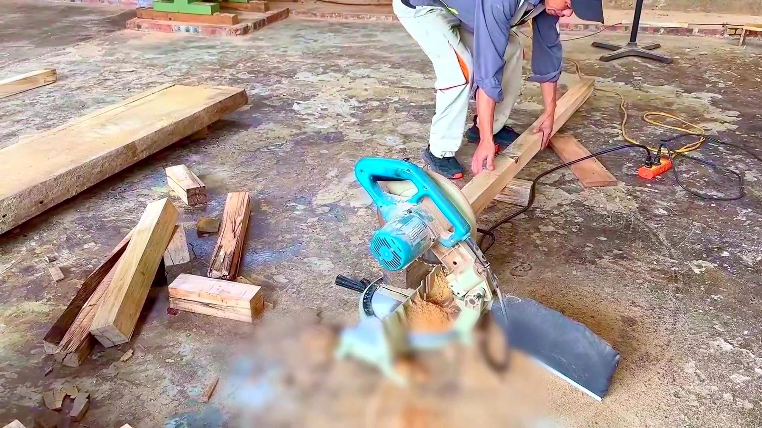 wood and bamboo pavilion build with miter saw - dimensional wood being crosscut on the outdoor miter-saw station
